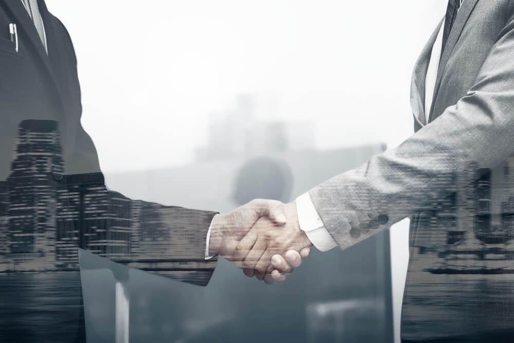 business partners in suits shaking hands