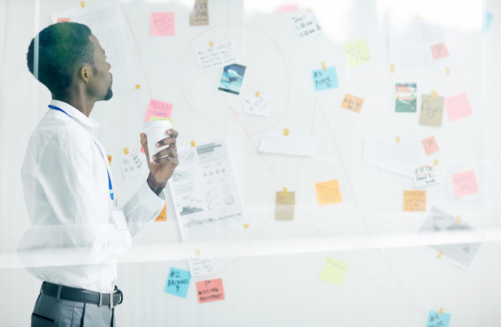 Businessman studying project details pinned to a white board