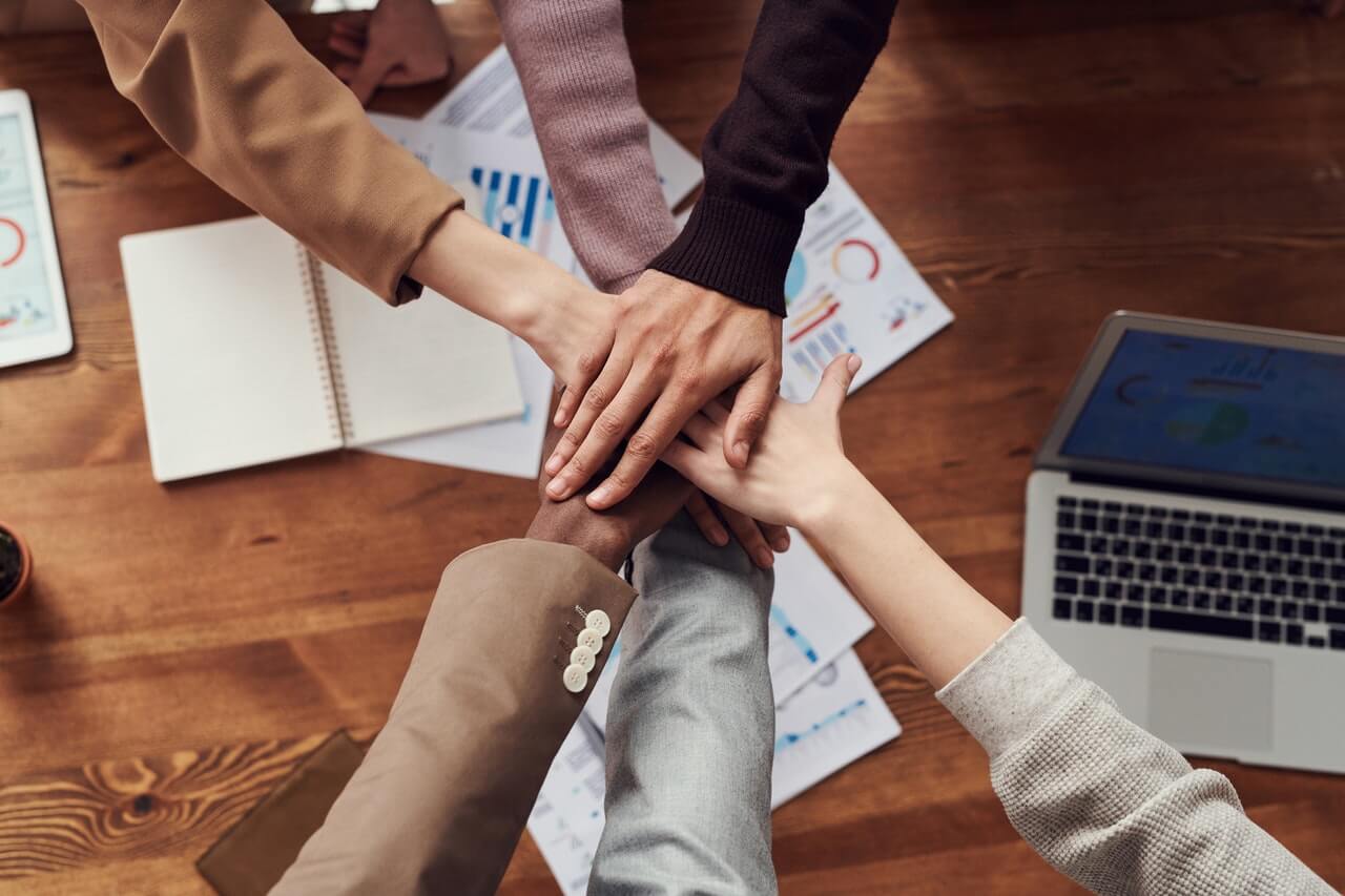 Group of hands in a hand-stack in a office