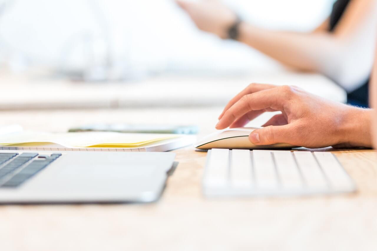 Person working with a mouse on a desk laptop