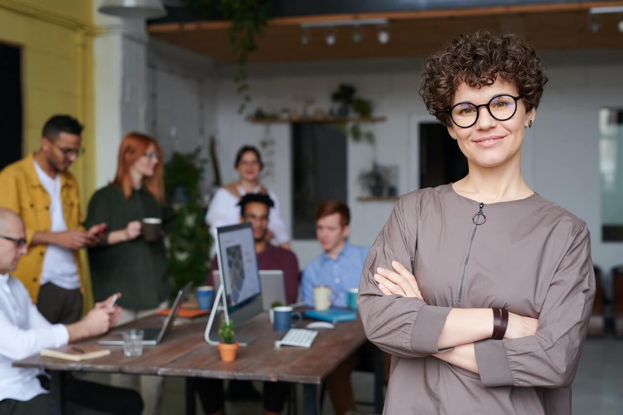 Woman wearing glasses standing in front of a business team