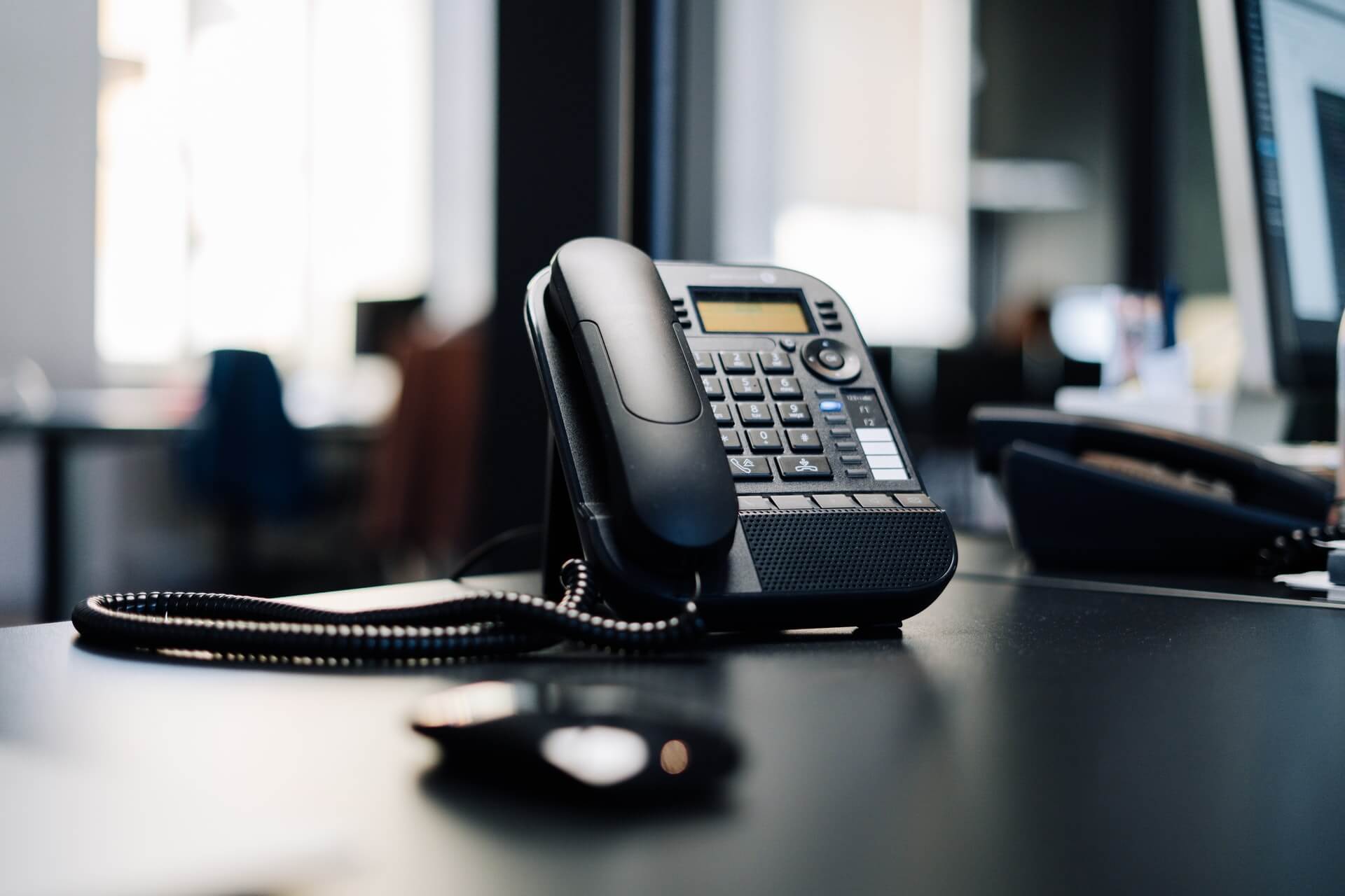 Black IP desk phone on an office table