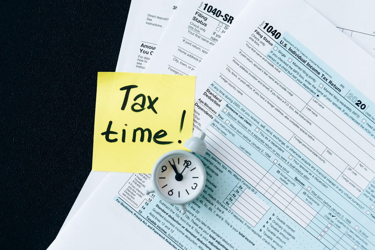 Bunch of tax files and a mini-clock on a desk