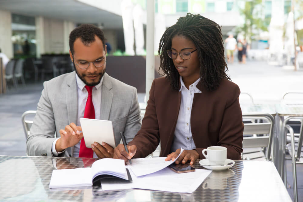 Businessman sitting beside a legal expert taking notes