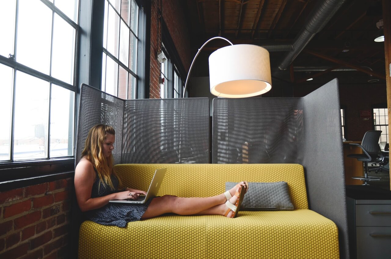 Woman on a couch working with a laptop