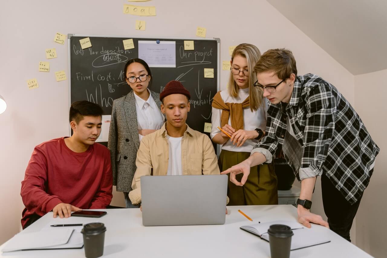 A Man Presenting to a group of people with a laptop