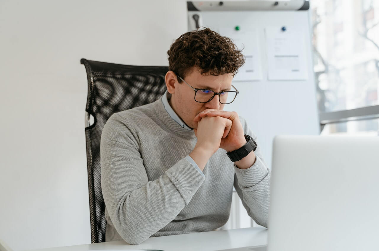 A-man-thinking-while-staring-at-his-laptop