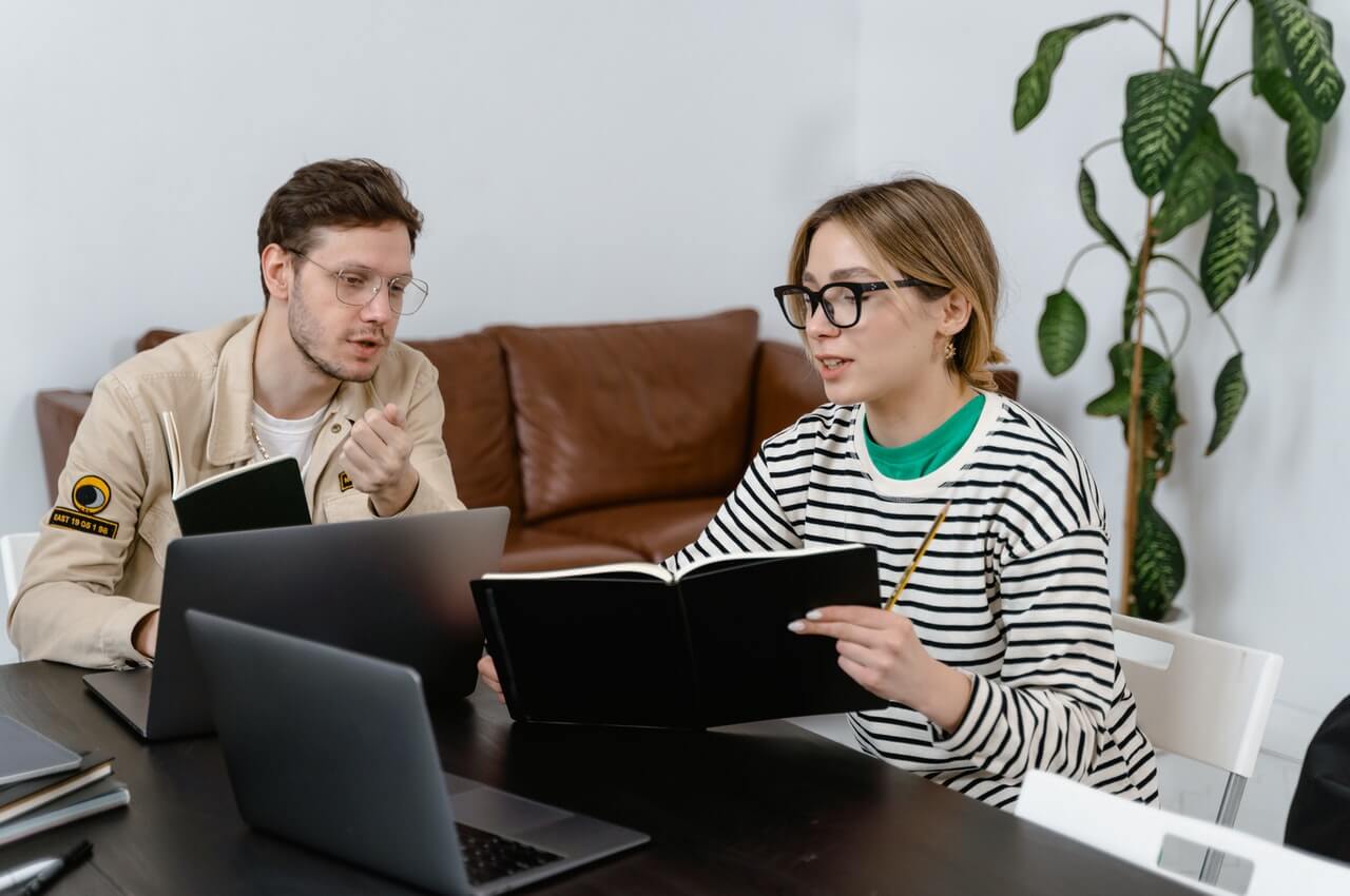 Two-employees-going-through-their-company-employee-handbook