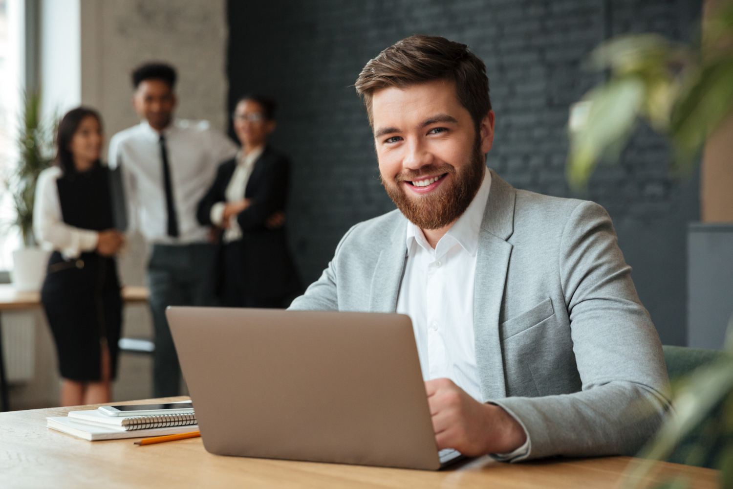 Cheer young businessman working with a laptop