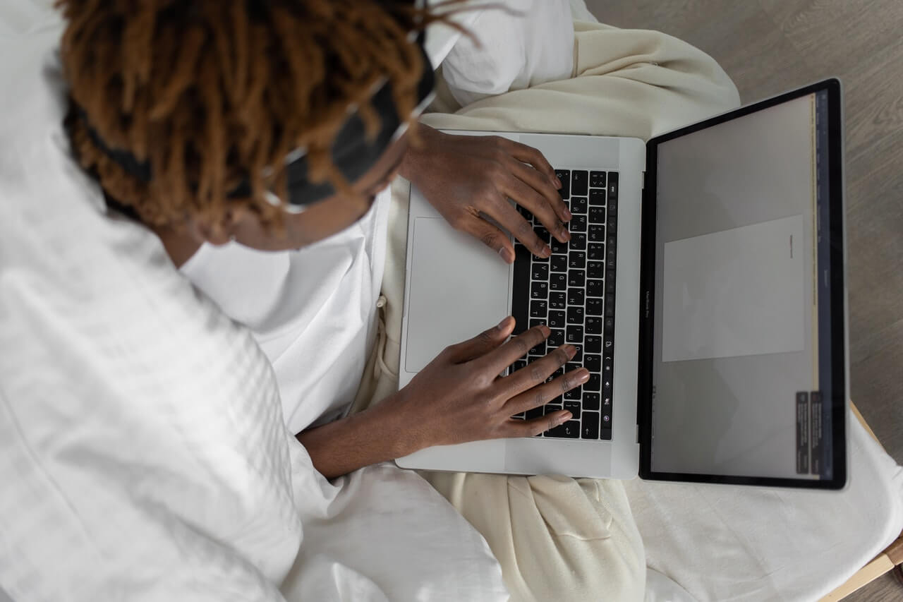 A person writing with his laptop