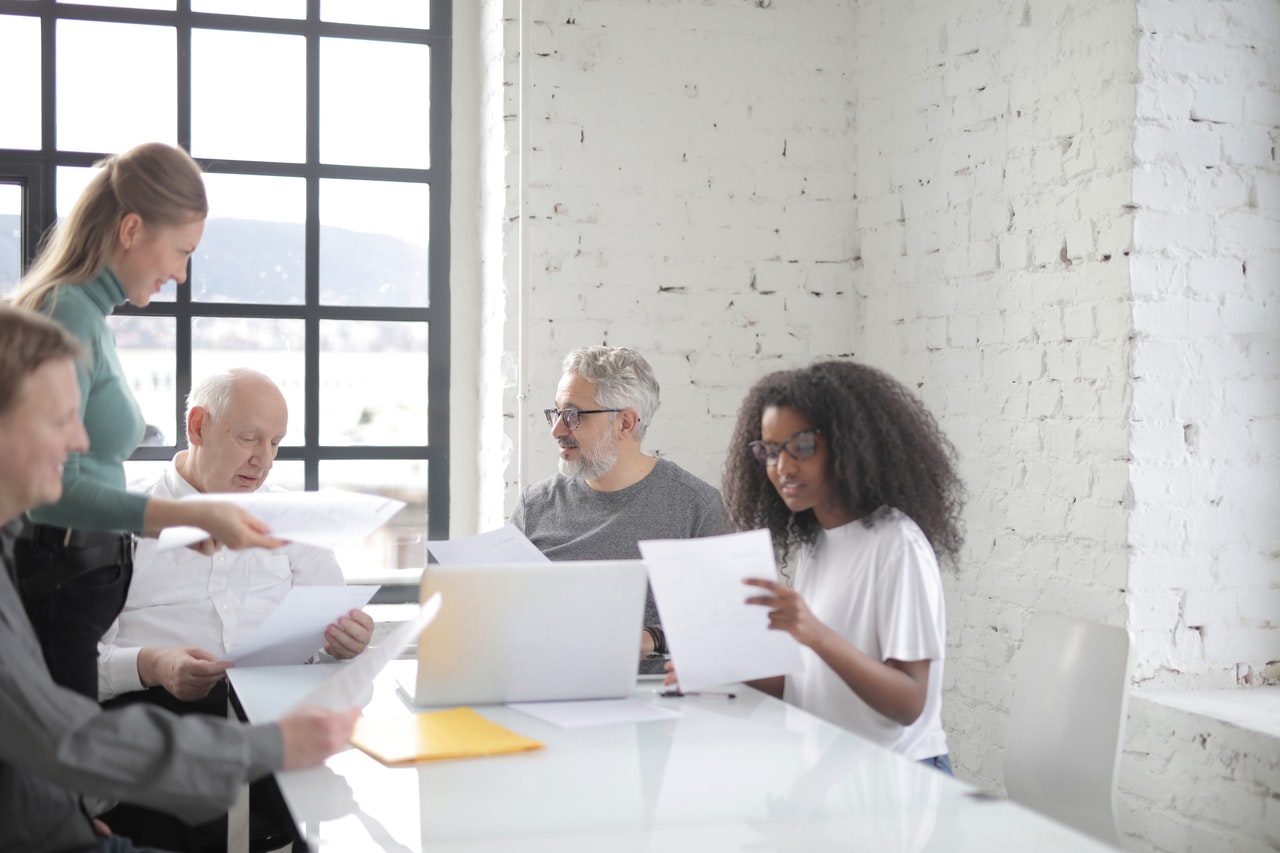 Colleagues communicating together while sitting at table in office