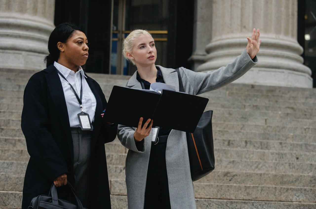 Formal businesswomen with document discussing