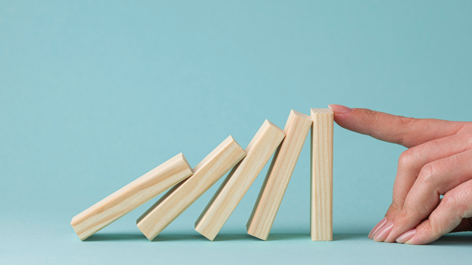 Hand stopping wooden blocks from falling