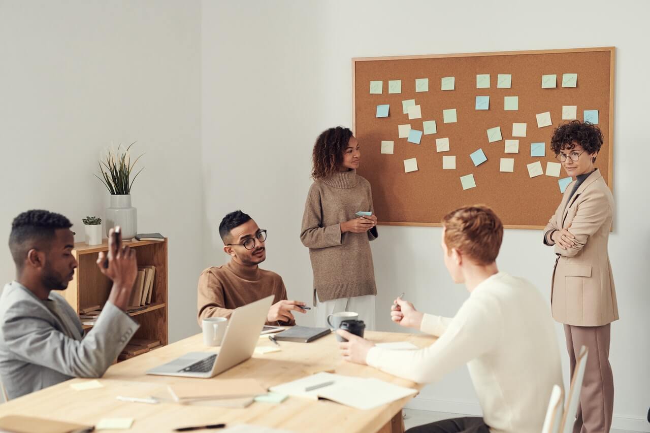 Women standing beside a board in a meeting