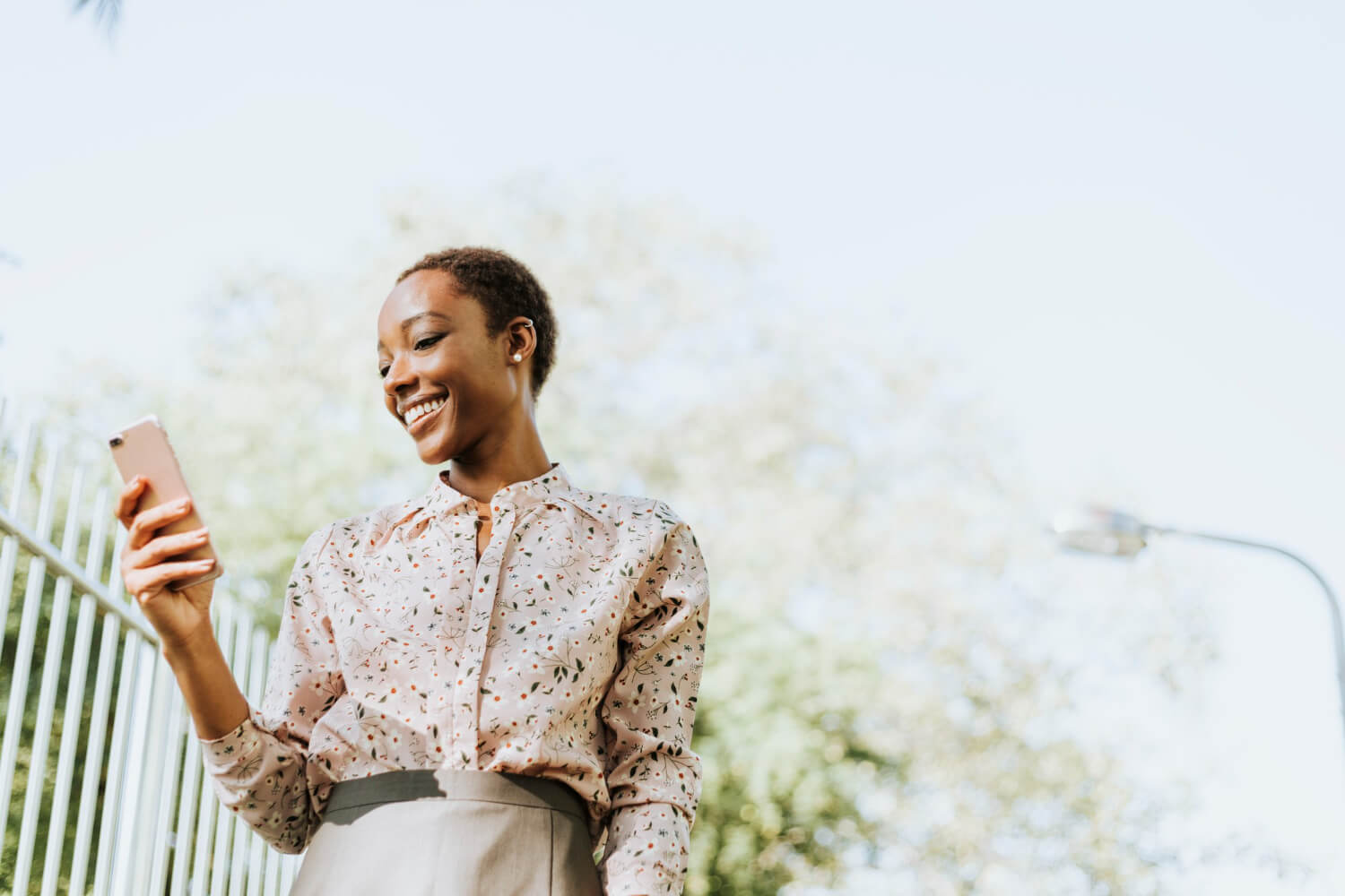 Young lady looking down at her phone smiling