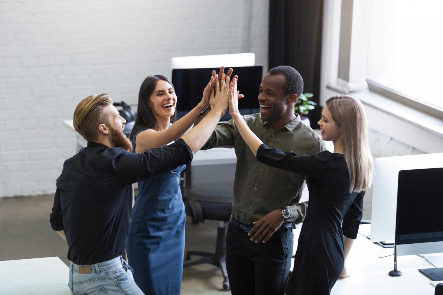 group-young-colleagues-giving-each-other-high-five