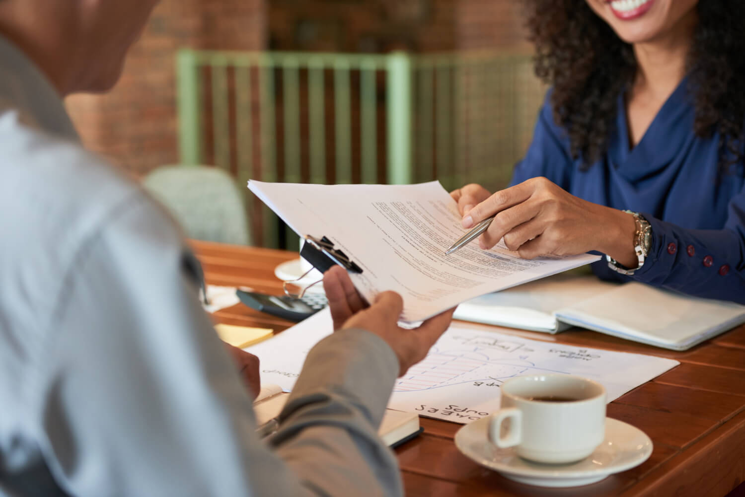 A woman passing a document to a businessman