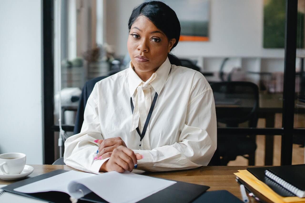 A-woman-stting-in-her-office-and-facing-the-camera.