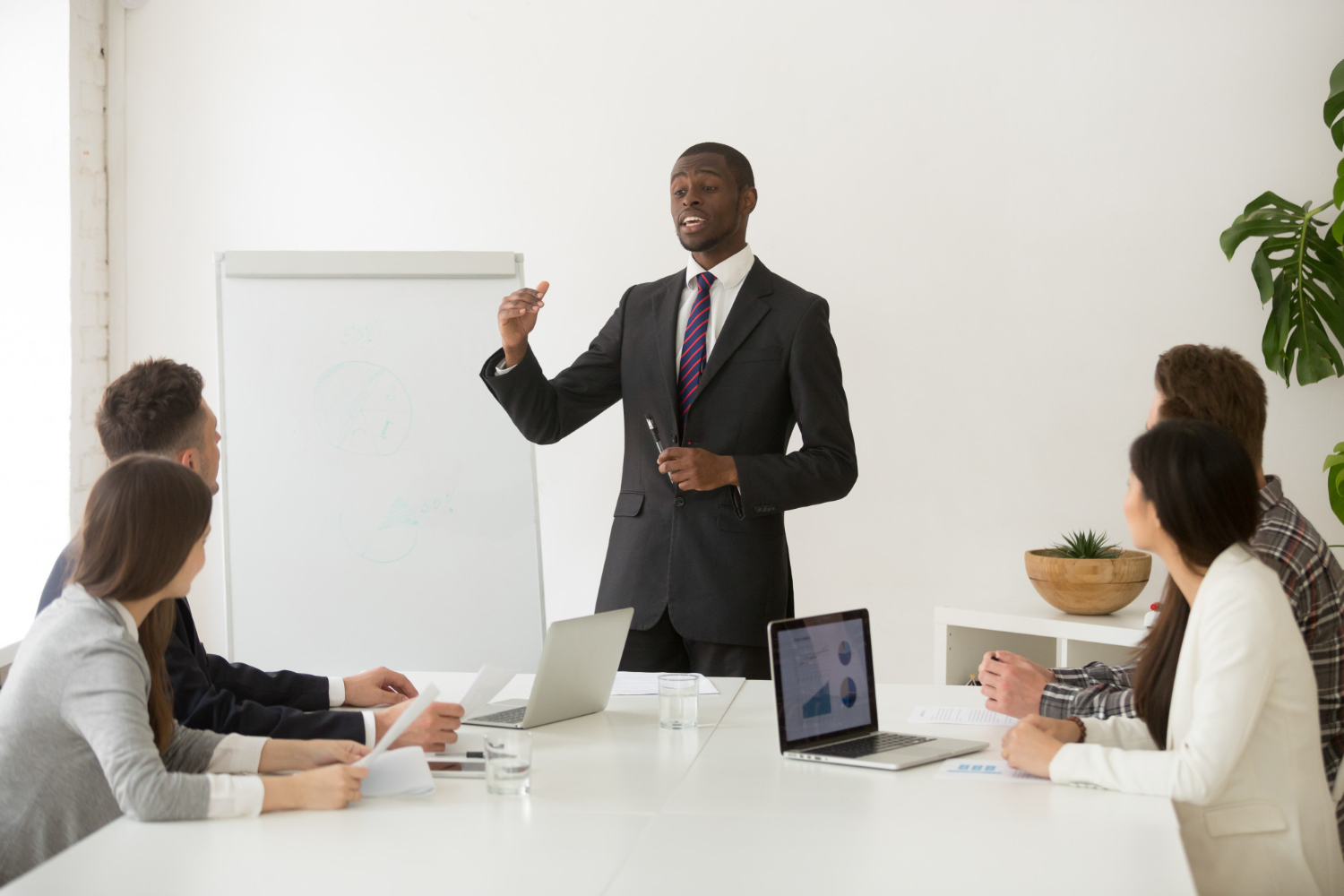 Business-coach-giving-presentation-to his team