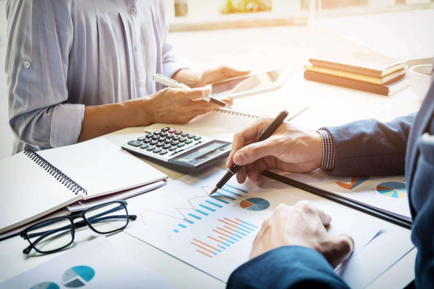 Business-man-making graphs report with a lady calculating