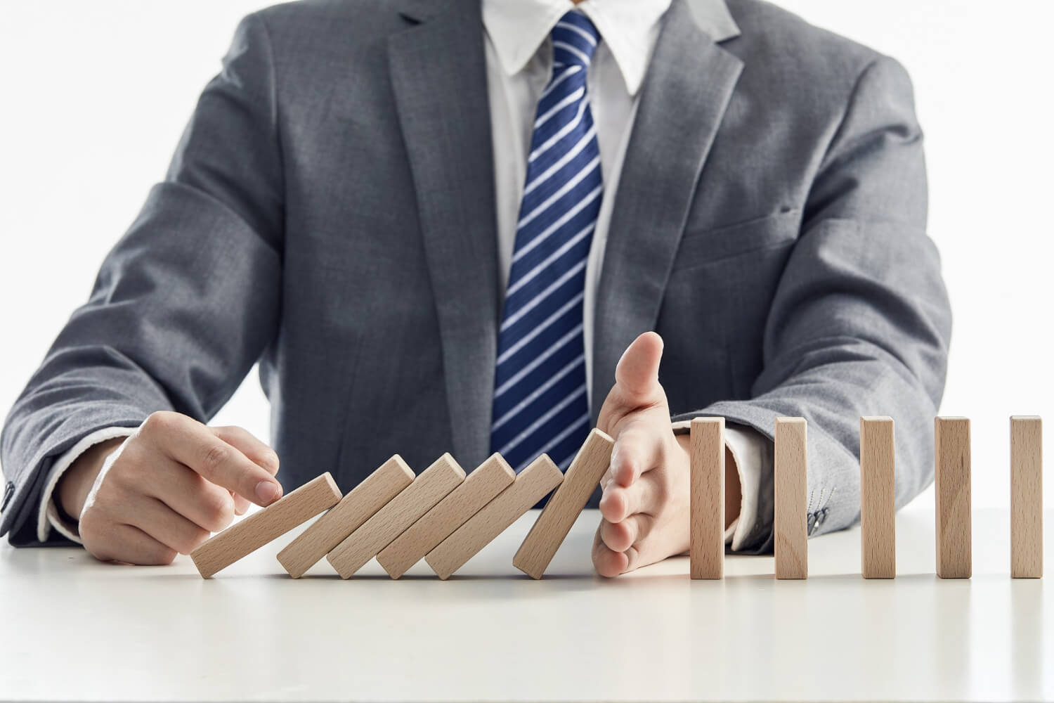 Businessman-suit-protecting-wooden-blocks-from-falling