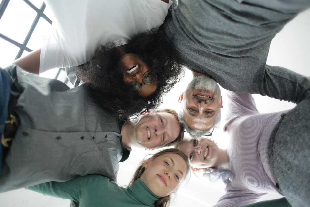 Group of people embracing each other in a circle during team building