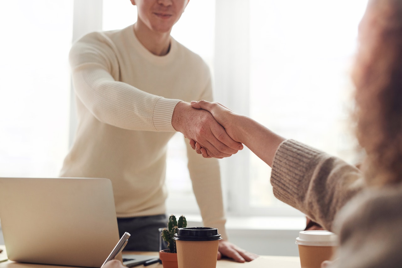 Man and Woman Near Table Having an Handshake