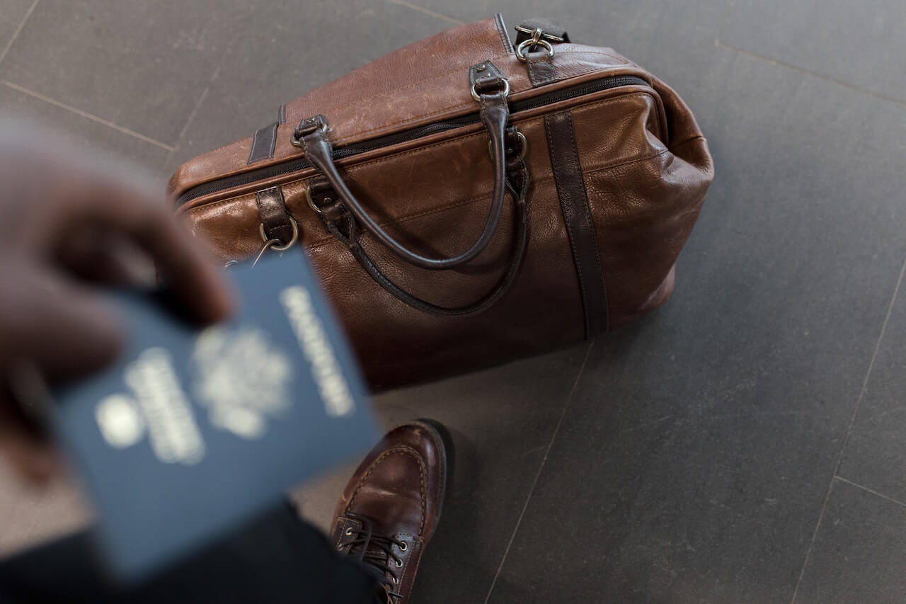 Brown leather traveling bag and a passport