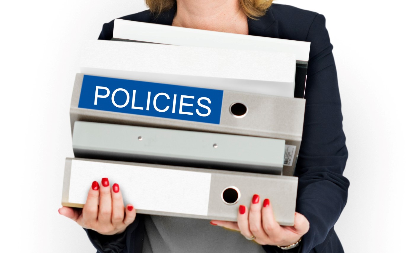 Woman holding books saying policies