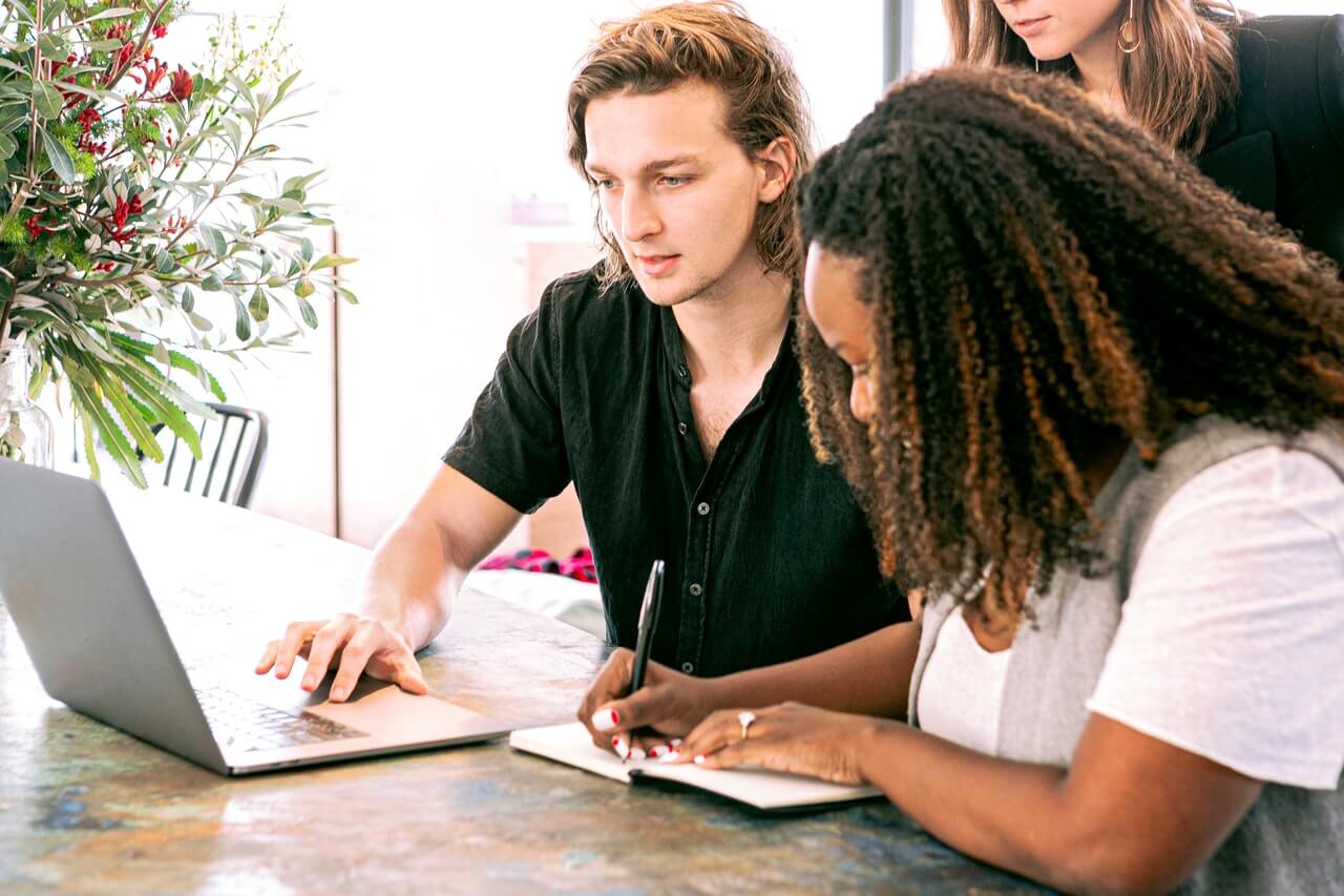 Man coaching a woman who's taking notes