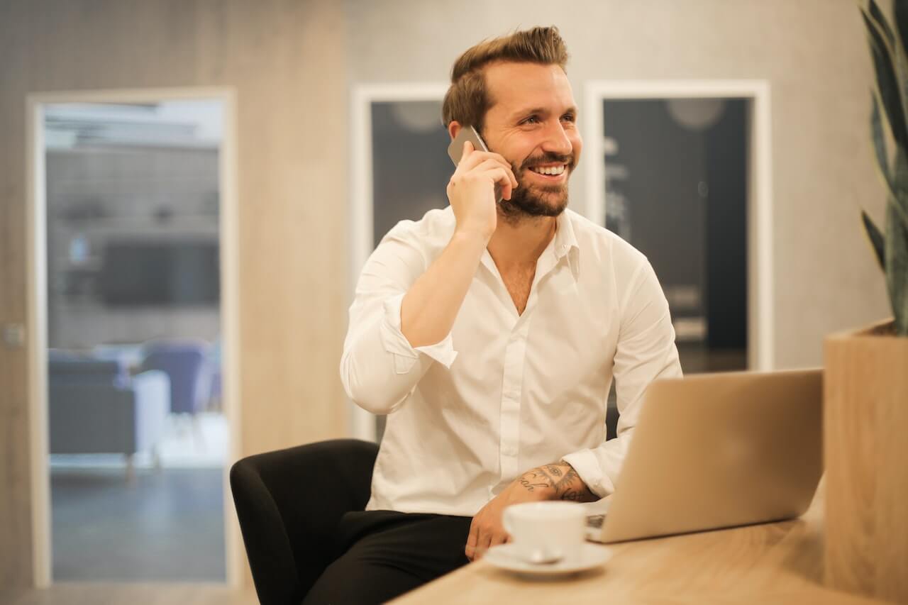 A man laughing over a conversation on the phone