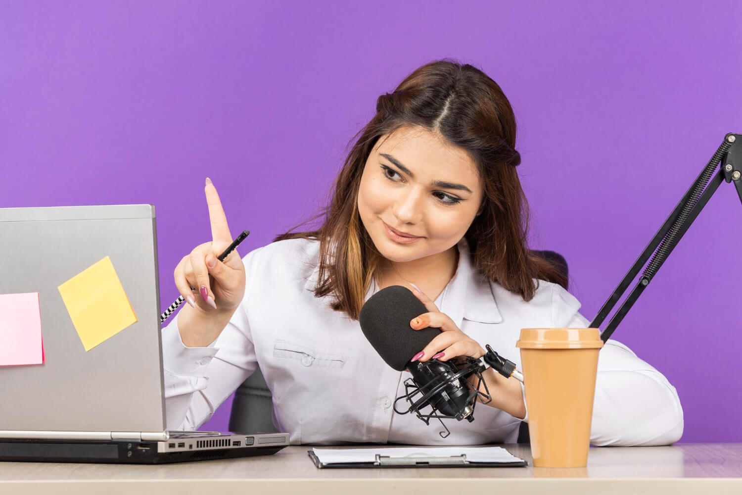 a-female-news-pdcaster-holding-the-mic-and-looking-at-her-system