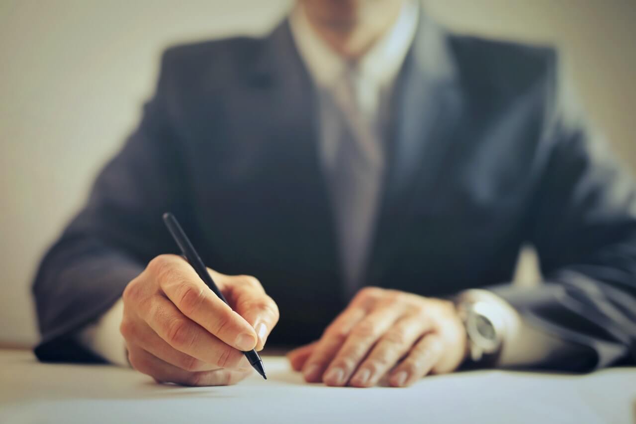 a-man-writing-in-his-office-desk