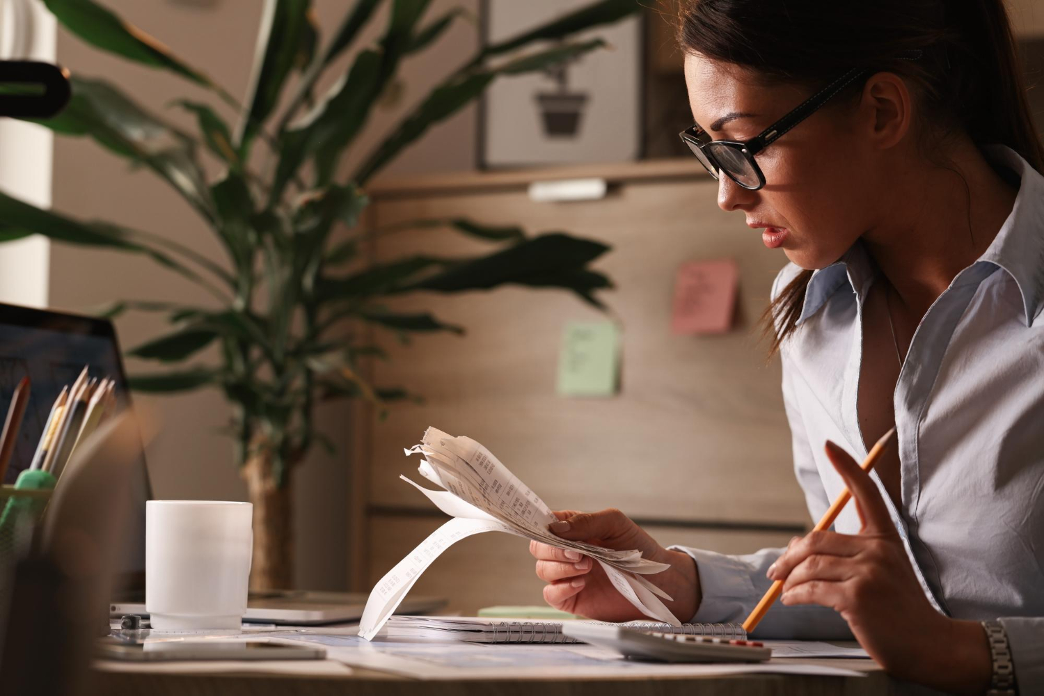 female-accountant-calculating-tax-bills-while-working-finances-office.