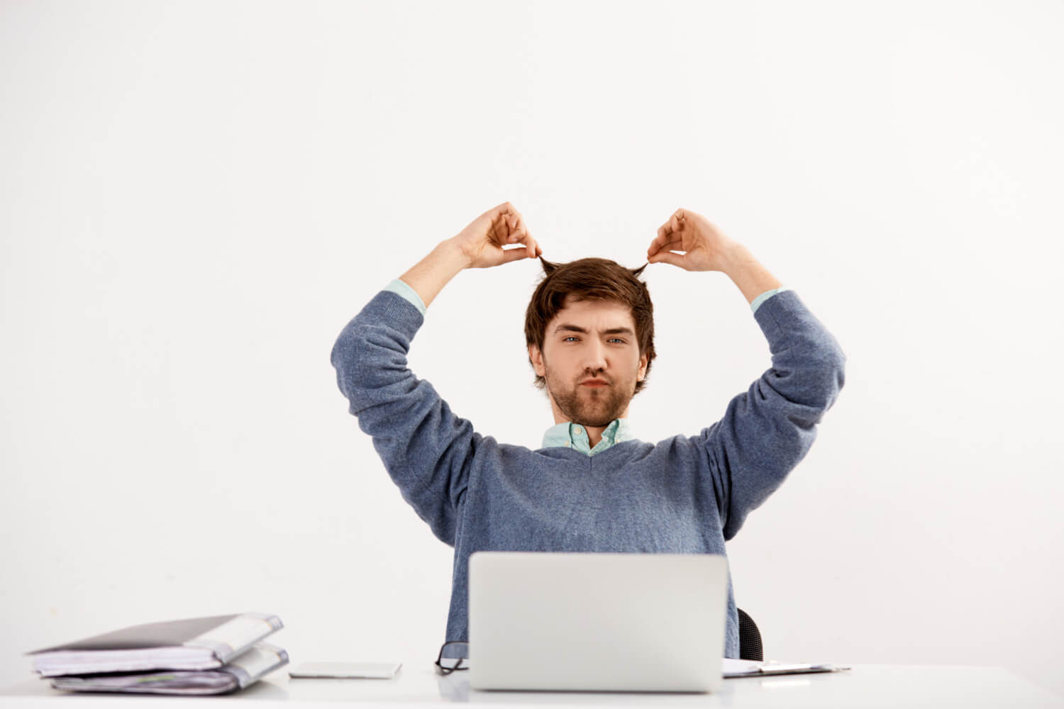 young-man-employee-working-with-laptop-office-desk-grimacing-playing-hair-procrastinating