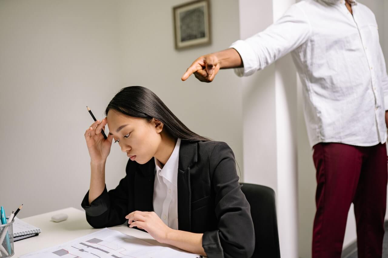 A Person Pointing Finger at a Woman in Black Blazer