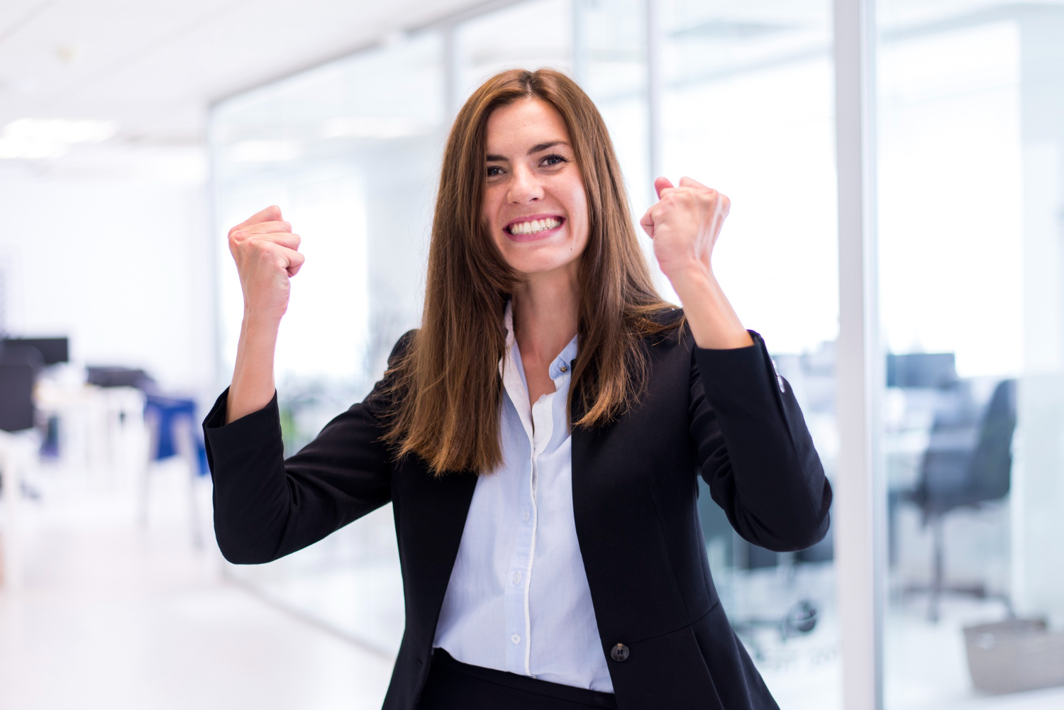 A-career-woman-raising-her-fist-as-a-sign-of-a-success.