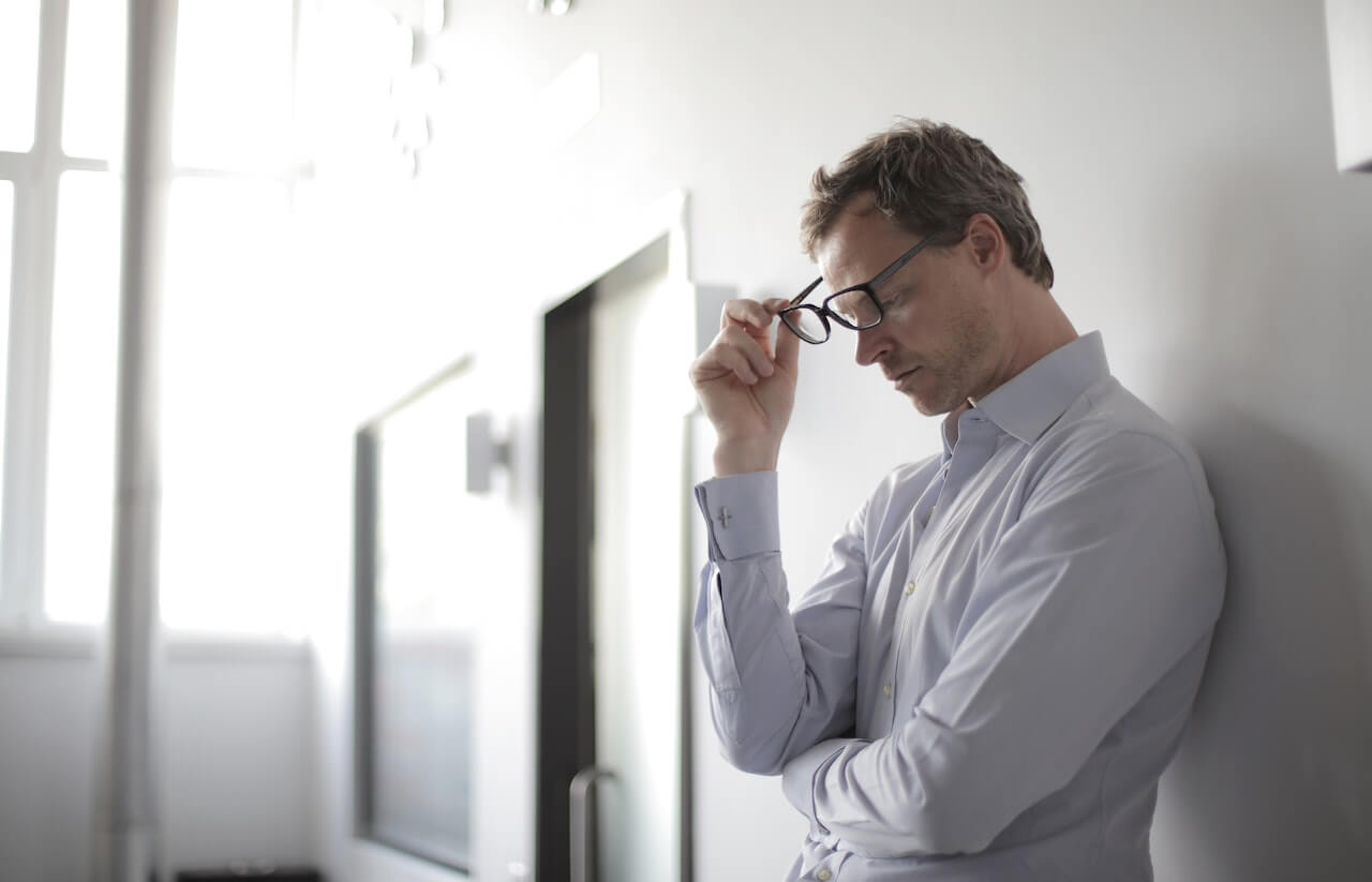 A-man-stressed-and-thinking-standing-on-a-wall.