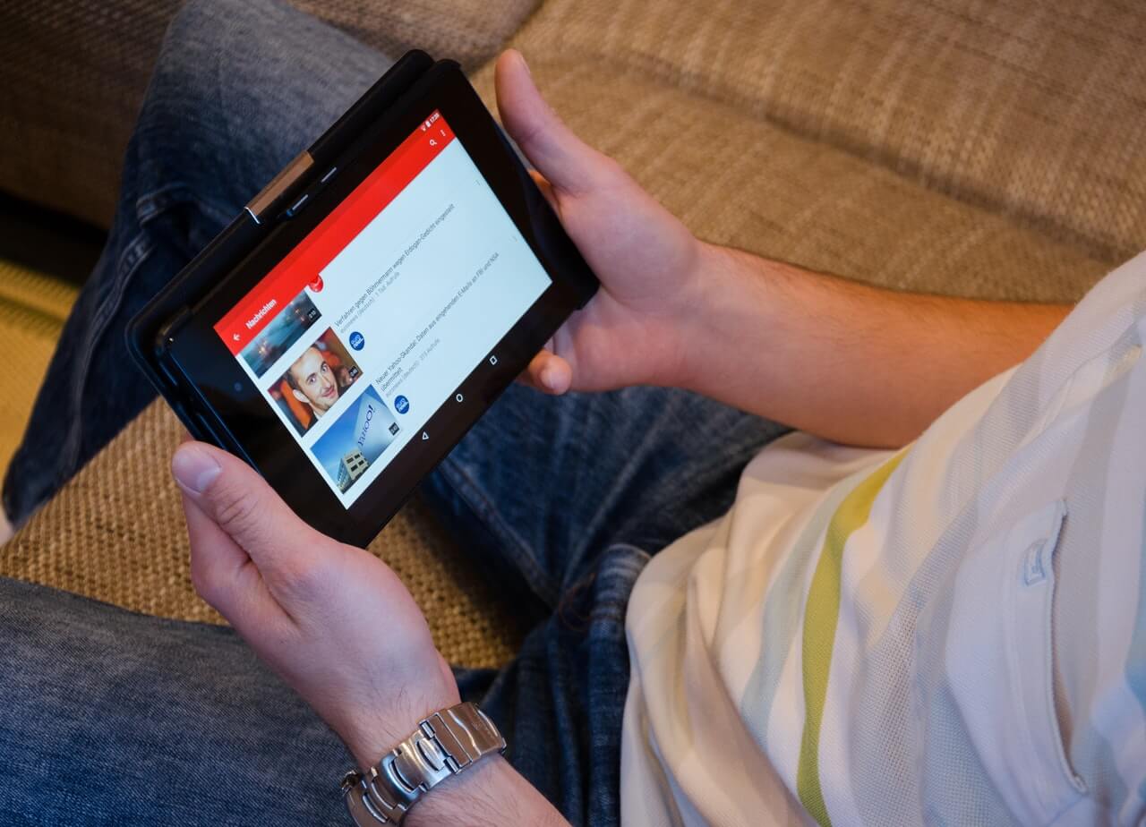 A man using his tab to checvk thyrough social media news