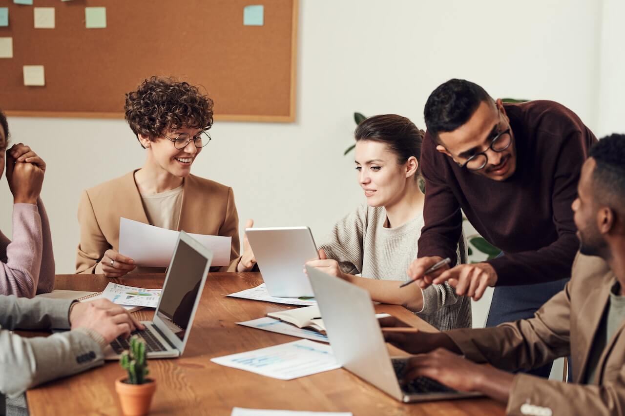 Group of People Gathered Around Wooden Table in a Meeting