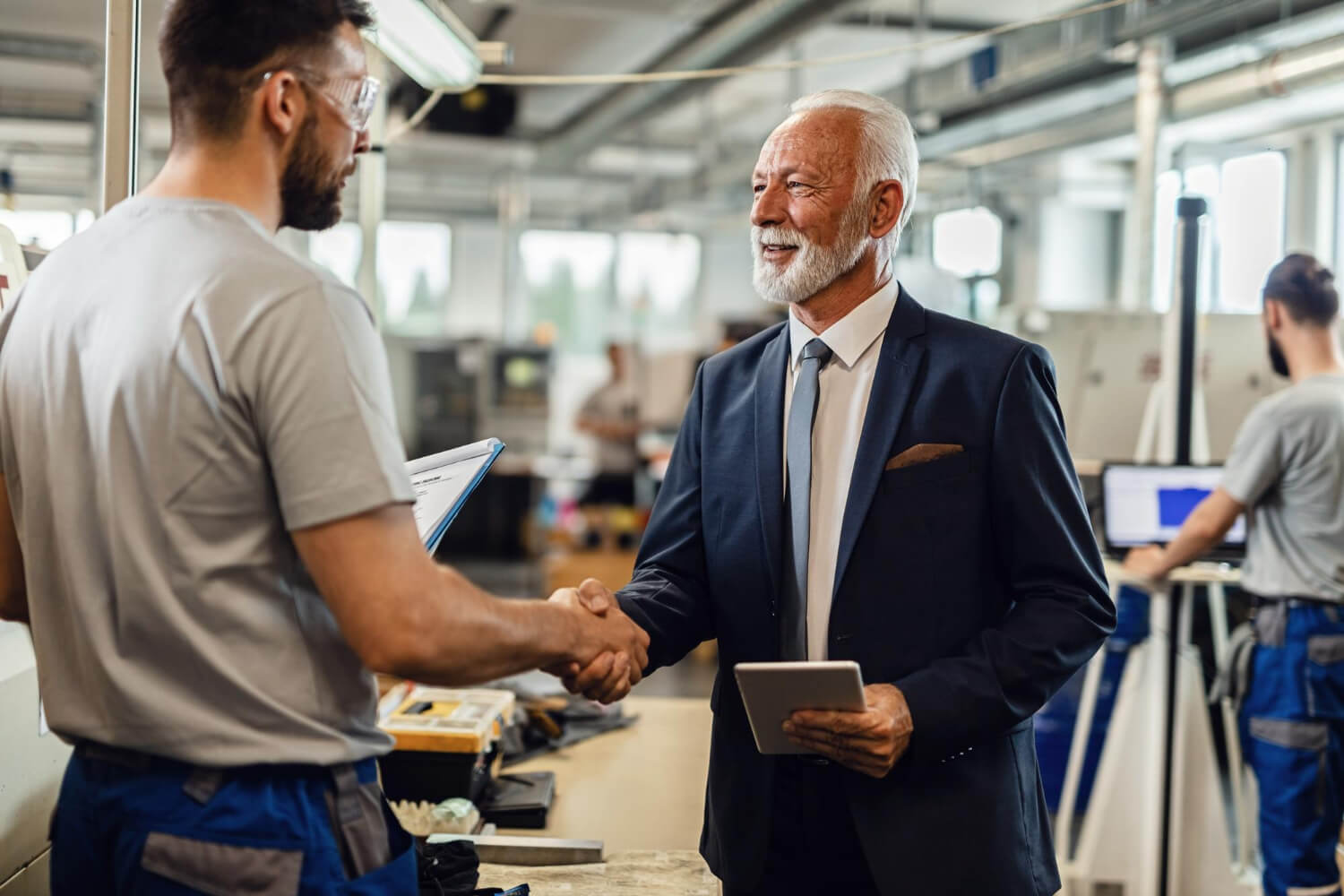 Happy-mature-company-manager-handshaking-with-worker-while-visiting-factory-plant