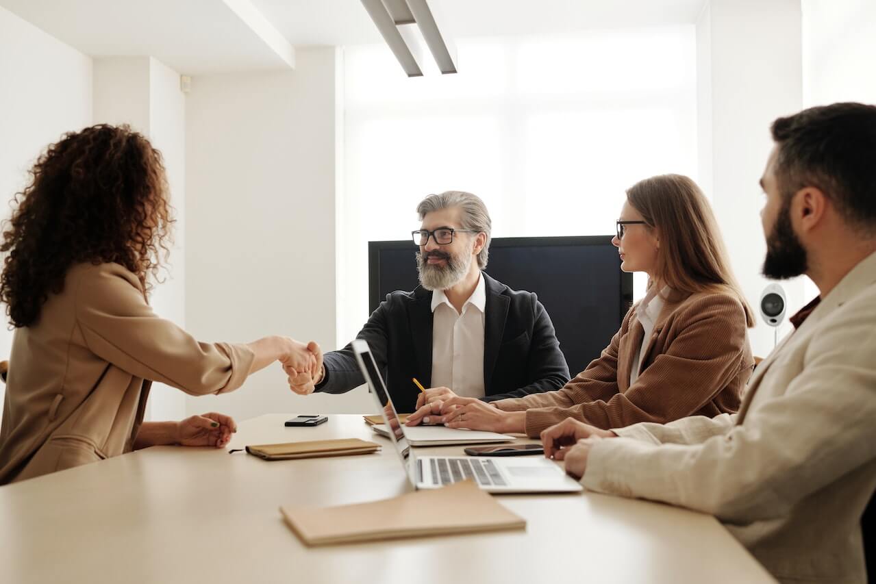 Man in a black suit having an handshake with a lady