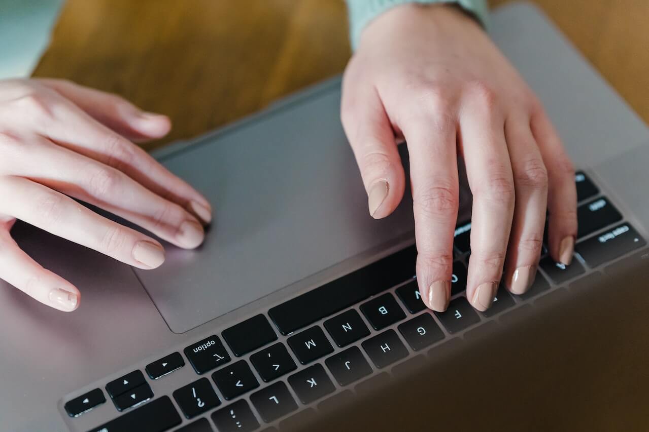 Person typing on keyboard of laptop