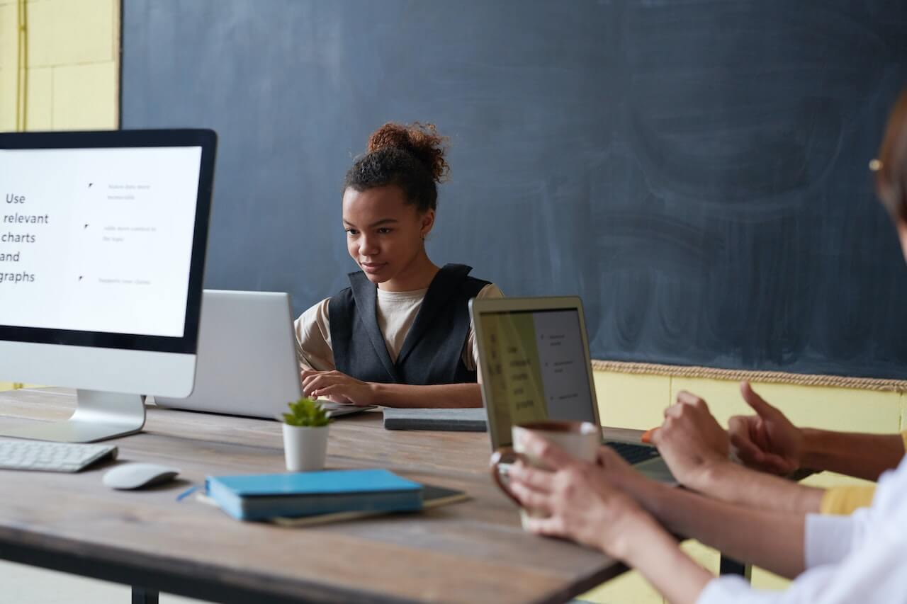 Woman Wearing Black Vest Using a Laptop While Working