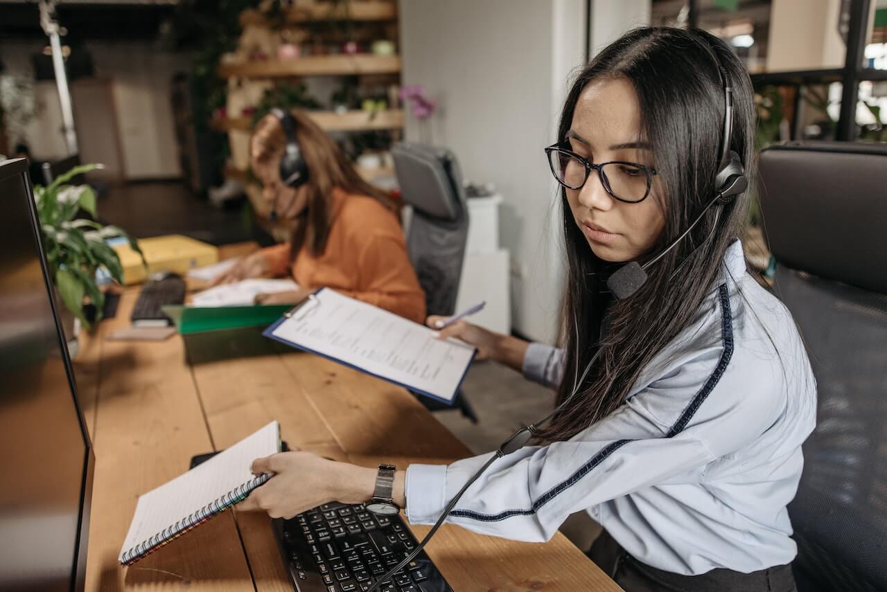 A woman in an office using headset to communicate at work