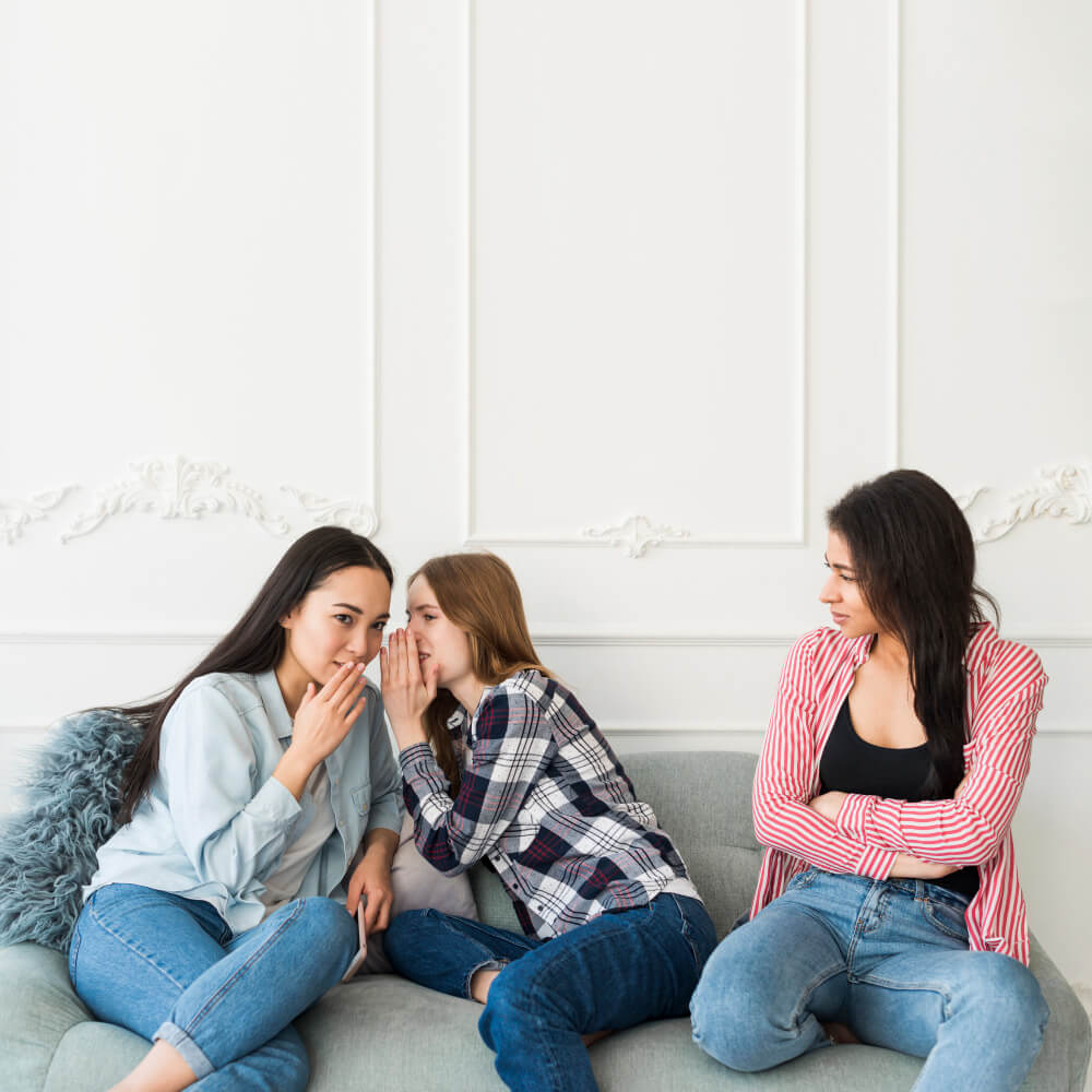 A woman whispering to her friend closely