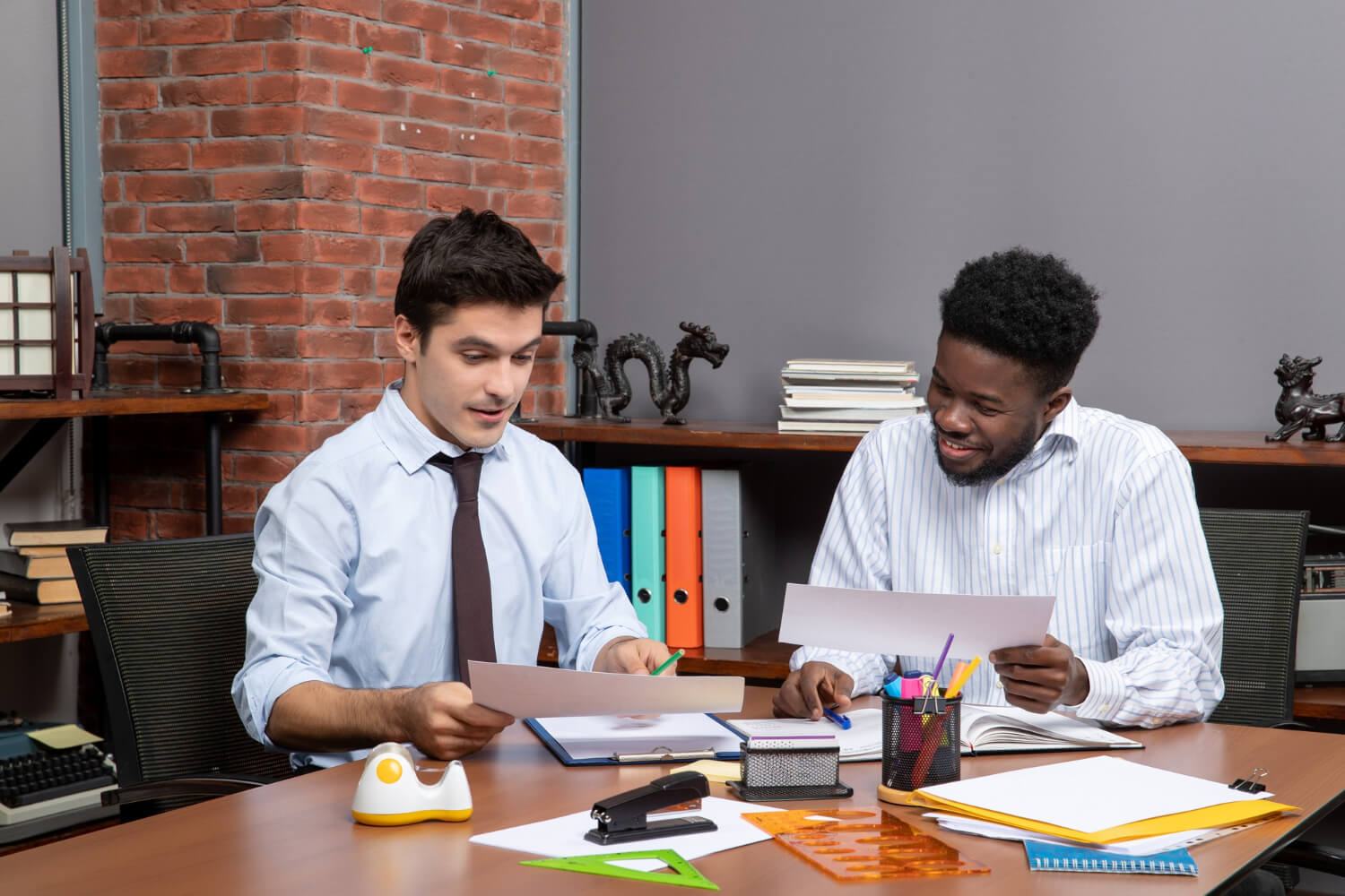 Two businessmen in formal wear preparing documents to file for ERC